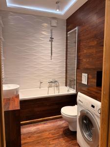 y baño con bañera, aseo y lavadora. en Home4You, en Cracovia 7 fotos más