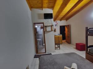 una cocina con techos de madera y una habitación con nevera. en Cecilia's Home Iguazú, en Puerto Iguazú