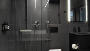 ヘルシンキにあるDesign home with sauna and spa in central Helsinkiの浴室のガラス扉付きシャワー