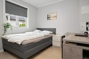 une chambre avec un lit, un bureau et une fenêtre dans l'établissement Urban comfort, 3BR with free parking in the heart of Tønsberg, à Tønsberg