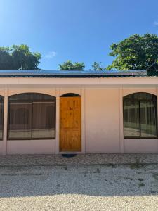 JicaralCabinas Los Cedros的白色的建筑,设有两扇窗户和一扇门