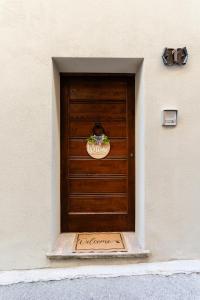una puerta de madera con una señal de bienvenida delante de ella en L'Angolo della Torre, en Bevagna