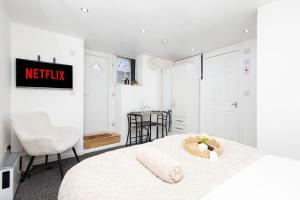 une chambre blanche avec un lit, une table et des chaises dans l'établissement Modern Cozy Flat 6 mins to City Parking & WiFi, à Killingbeck 13 autres photos