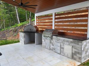 a outdoor kitchen with a grill and smoker on a patio at Altitude Adjustment in Nellysford