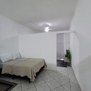 a bedroom with a bed in a white room at Aconchego GG in Indaiatuba