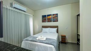 una camera da letto con un letto e un asciugamano sopra di Flat & Hotel Executive a Confresa