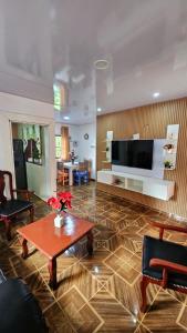 uma sala de estar com uma mesa e uma grande televisão em Springhouse jarabacoa em Jarabacoa