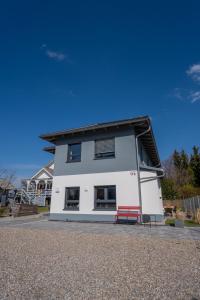 a white building with a red bench in front of it at Ammersee-Nest Dießen in Dießen am Ammersee