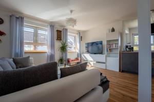 a living room with a couch and a tv at Ammersee-Nest Dießen in Dießen am Ammersee