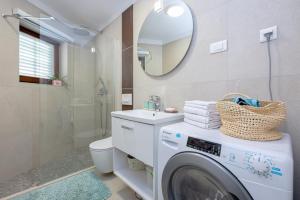 a bathroom with a washing machine and a sink at Studio Apartment "Dida" with Free Private Parking in Solin