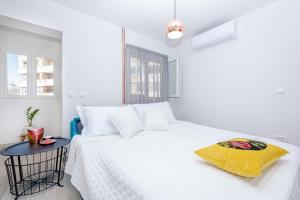 a white bedroom with a white bed with a yellow pillow at Studio Apartment "Dida" with Free Private Parking in Solin