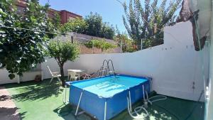 une baignoire bleue dans une cour à côté d'un mur blanc dans l'établissement Habitacion Privada 2 Personas Toledo, à Tolède