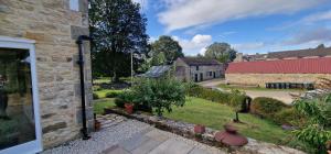 3 Bedroom Country Family Home near Masham في ماشام: منظر خارجي لمنزل مع فناء ومبنى