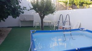une piscine avec des chaises et une table et un arbre dans l'établissement Habitacion Privada 2 Personas Toledo, à Tolède