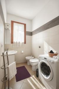 a bathroom with a washing machine and a toilet at Residenze Italia in Sesto San Giovanni +118 photos