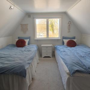two twin beds in a room with a window at Stuga på hästgård in Svenstorp