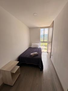 a bedroom with a bed and a large window at Apartamento en Manizales in Manizales