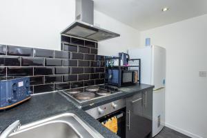 une cuisine avec une cuisinière et un réfrigérateur dans l'établissement Modern Cozy Flat 6 mins to City Parking & WiFi, à Killingbeck