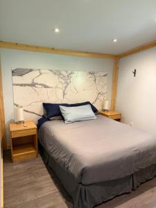 ein Schlafzimmer mit einem Bett mit zwei Nachttischen und zwei Lampen in der Unterkunft Pine Marten Wilderness Cabin in Golden