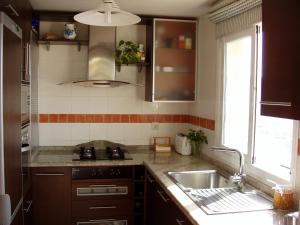 a kitchen with a sink and a stove and a window at Casa José in La Herradura