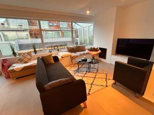 ein Wohnzimmer mit zwei Sofas und einem Flachbildfernseher in der Unterkunft Zoute74 - Luxury Penthouse in Knokke-Heist