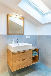 a bathroom with a sink and a mirror at Gästehaus zum Thoma in Kreuth