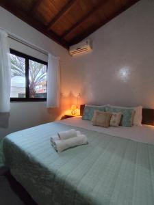 a bedroom with a large bed with a large window at Pousada do Betão in Guarda do Embaú +130 photos