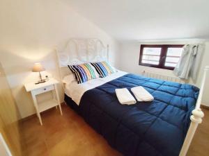 une chambre avec un lit avec une couverture bleue et une table dans l'établissement Caudiel entre Sierras, à Caudiel