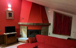 a red living room with a red couch and a fireplace at A Casa di Cheope in Bettolelle