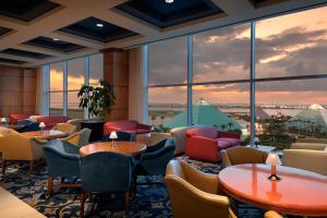 restauracja ze stołami i krzesłami oraz dużym oknem w obiekcie Moody Gardens Hotel Spa and Convention Center w mieście Galveston