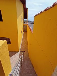 a yellow building with a bench on the side of it at Haja Luz Casa Pousada 1 em Itaquaquecetuba in Itaquaquecetuba