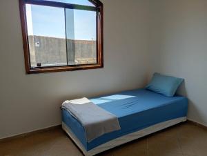 a bed in a room with a window at Haja Luz Casa Pousada 1 em Itaquaquecetuba in Itaquaquecetuba