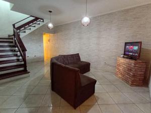 a living room with a couch and a television at Haja Luz Casa Pousada 1 em Itaquaquecetuba in Itaquaquecetuba