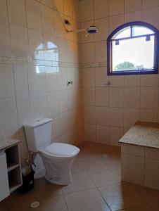a bathroom with a toilet and a window at Haja Luz Casa Pousada 1 em Itaquaquecetuba in Itaquaquecetuba +3 photos