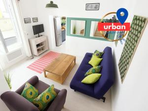 - un salon avec un canapé bleu et des oreillers jaunes dans l'établissement Duplex du Cloître 75m2, à Moissac