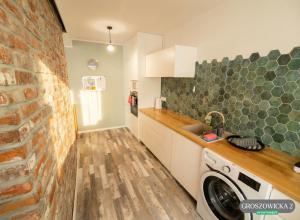 a kitchen with a brick wall and a washing machine at Przytulne i ciepłe mieszkanie w spokojnej dzielnicy Opola in Opole +8 photos