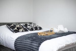 un lit avec une couverture et des oreillers noirs et blancs dans l'établissement Cozy Studio Flat, 7mins from CENTRE, Parking, WiFi & Netflix, à Killingbeck