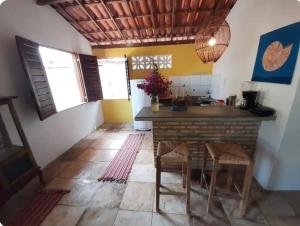 een keuken met een tafel en stoelen in een kamer bij Chalé Taiba in São Gonçalo do Amarante
