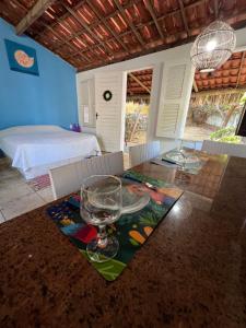 een eetkamer met een glazen tafel en een bed bij Chalé Taiba in São Gonçalo do Amarante