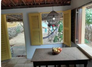 een fruitschaal op een tafel in een kamer met ramen bij Chalé Taiba in São Gonçalo do Amarante