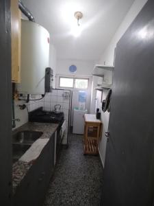 eine kleine Küche mit Spüle und Herd in der Unterkunft una caricia al alma in Neuquén