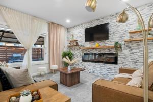 a living room with a brick wall with a fireplace at The Copperleaf Luxury Retreat with Hot tub in Calgary