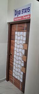 eine Holztür mit einem Schild darüber in der Unterkunft Diya STAYS in Rāmpur Hāt