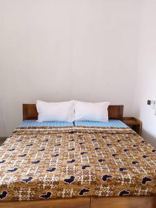 Una cama en una habitación con una colcha encima en Hotel Devotion, en Komé