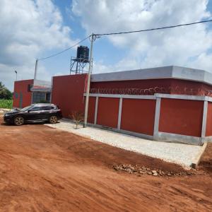 un coche aparcado delante de un edificio rojo en Hotel Devotion, en Komé