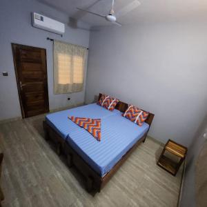 Un dormitorio con una cama azul con almohadas. en Hotel Devotion, en Komé