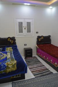 1 dormitorio con 2 camas y alfombras en el suelo en family home, en Siwa 8 fotos más