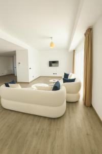 deux canapés blancs assis dans un salon dans l'établissement Luxury Penthouse-Poiana Brasov, à Poiana Brasov