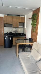 een keuken met een tafel en een bank in een kamer bij Bela Vista Residence Piscina Privativa in Porto De Galinhas