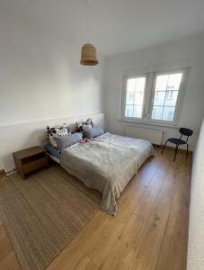 a bedroom with a bed and a table and two windows at Entire house with garden - exclusively for your group in Leipzig +26 photos